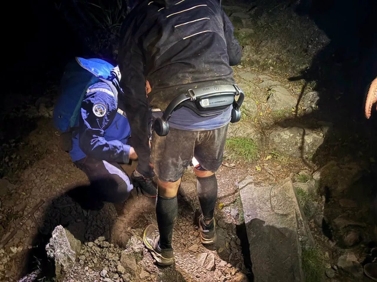 Un concurrent du Grand Raid porte un exosquelette à la taille et aux cuisses pendant une intervention nocturne du PGHM de La Réunion.