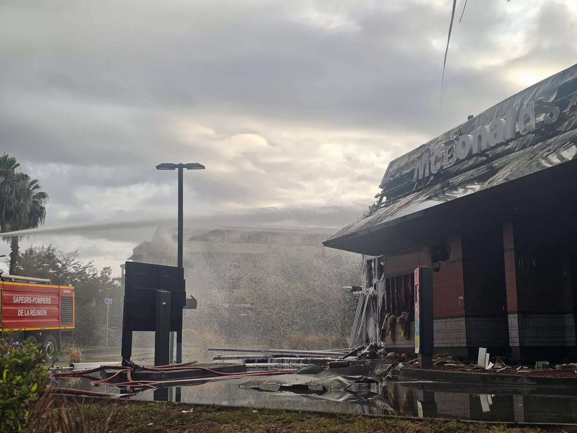 Le restaurant McDonald’s de La Possession endommagé par un incendie, avec un véhicule des sapeurs-pompiers à proximité.